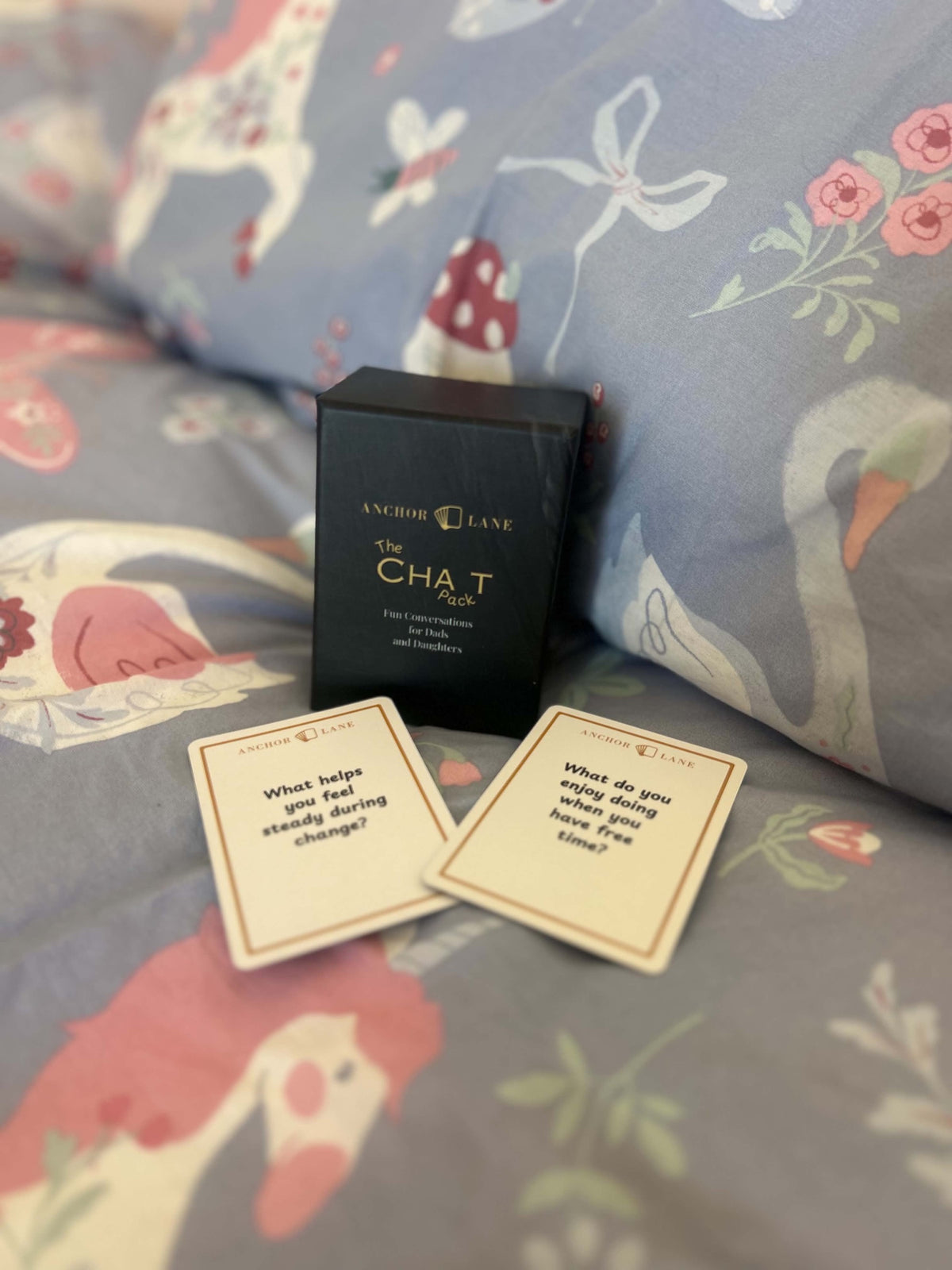 The Chat Pack conversation cards on a child's bed, bedtime questions for dads and daughters