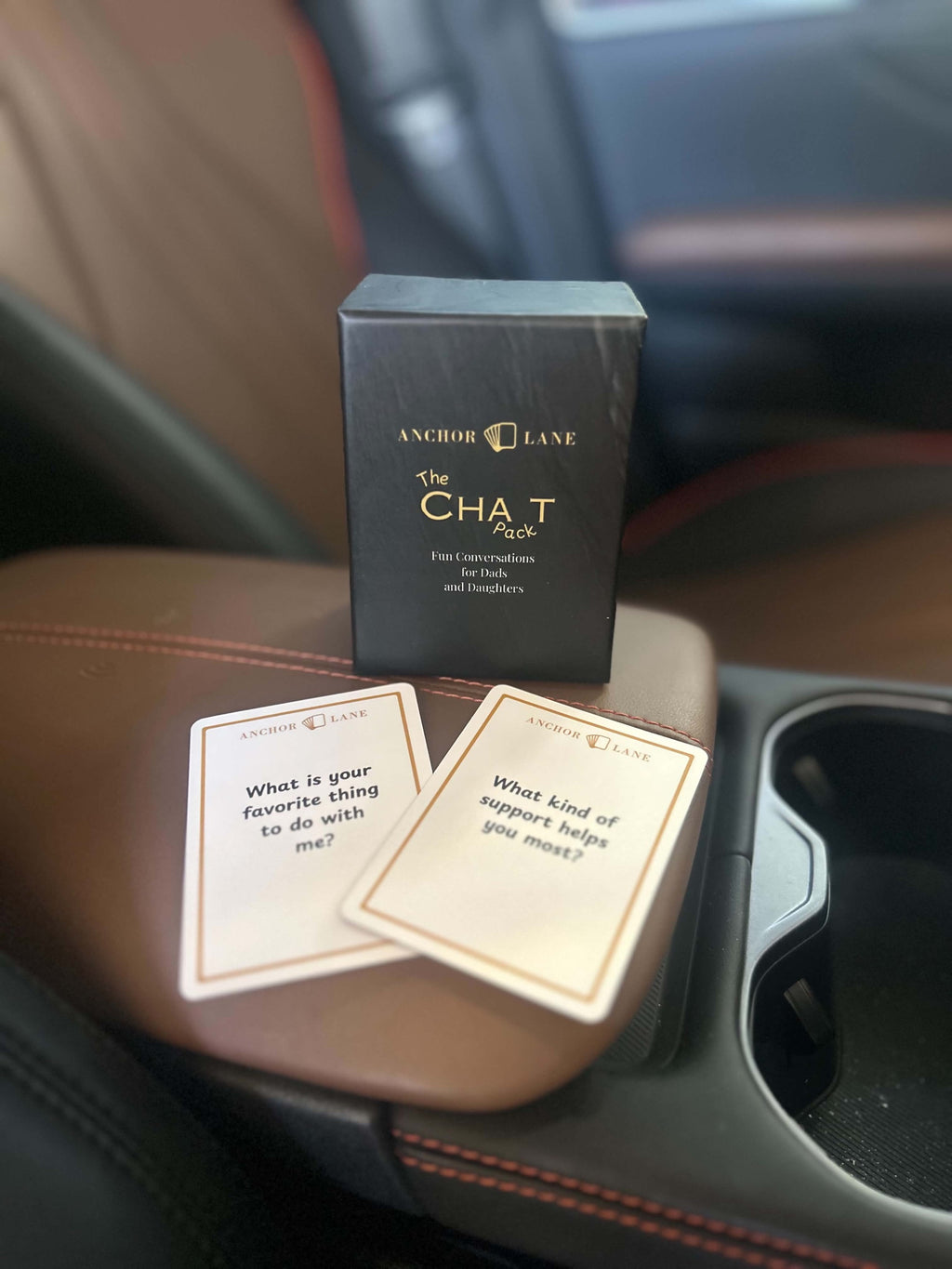 Anchor Lane Chat Pack on a car console with two conversation cards, travel conversation cards for dads and daughters